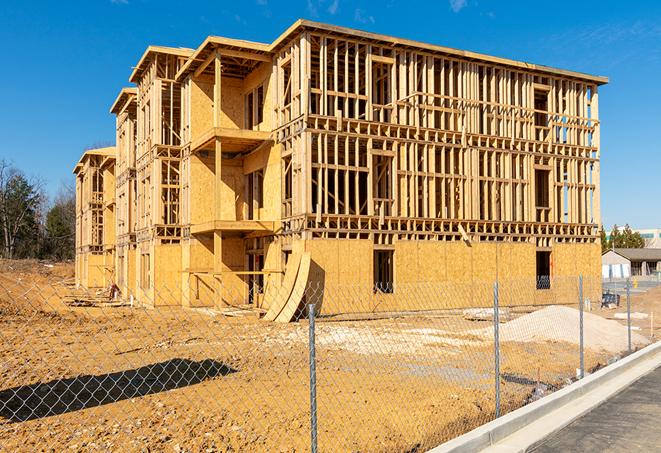 a close-up of temporary chain link fences enclosing a job site, signaling progress in the project's development in Crockett